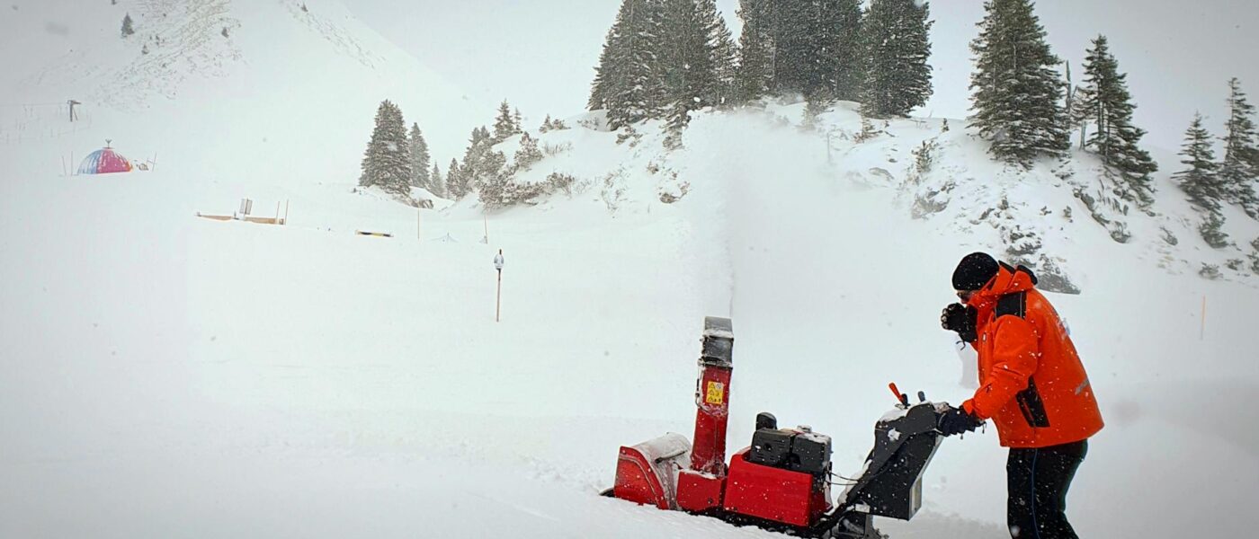 man snow clearing near hill
