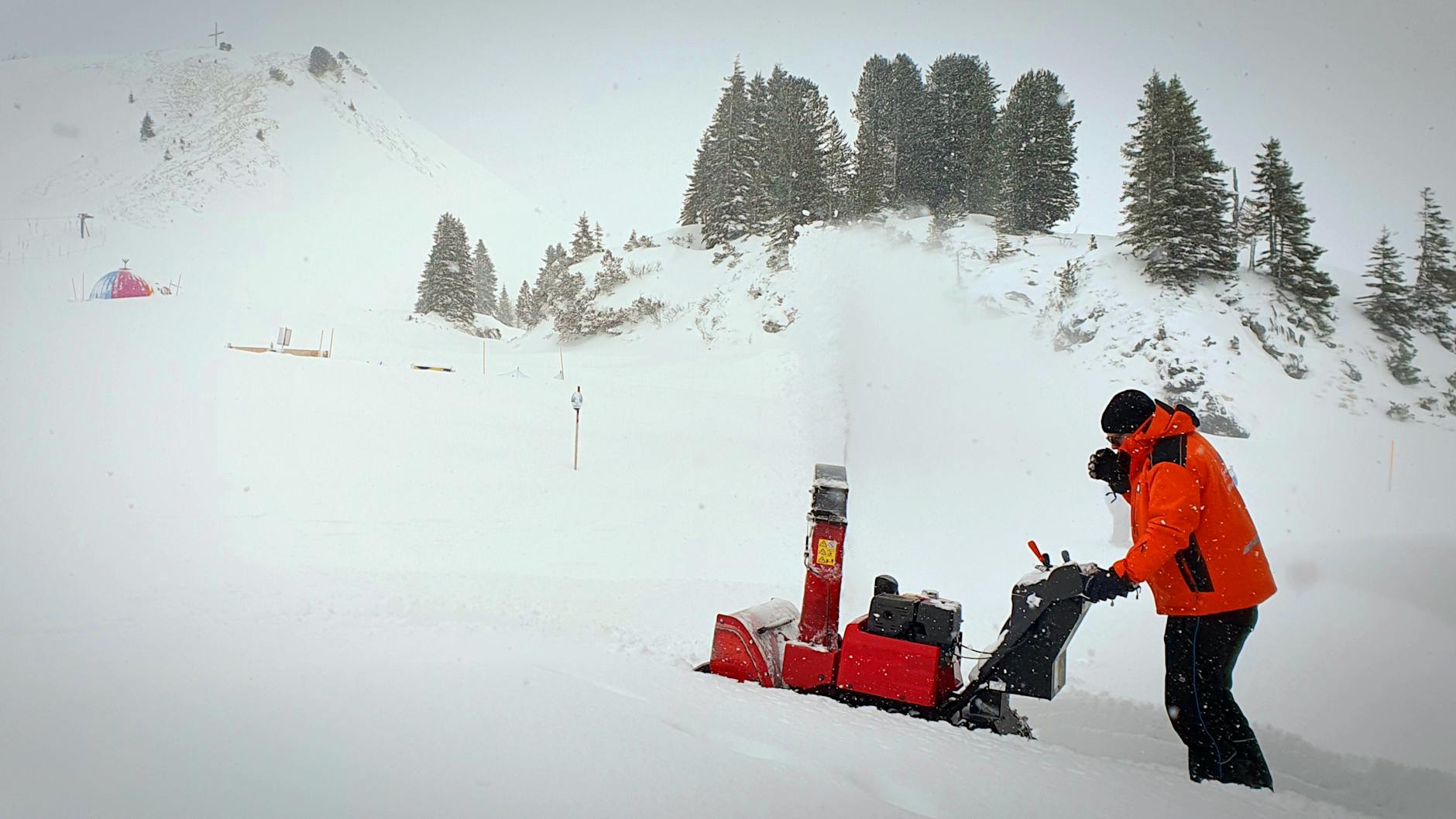 man snow clearing near hill