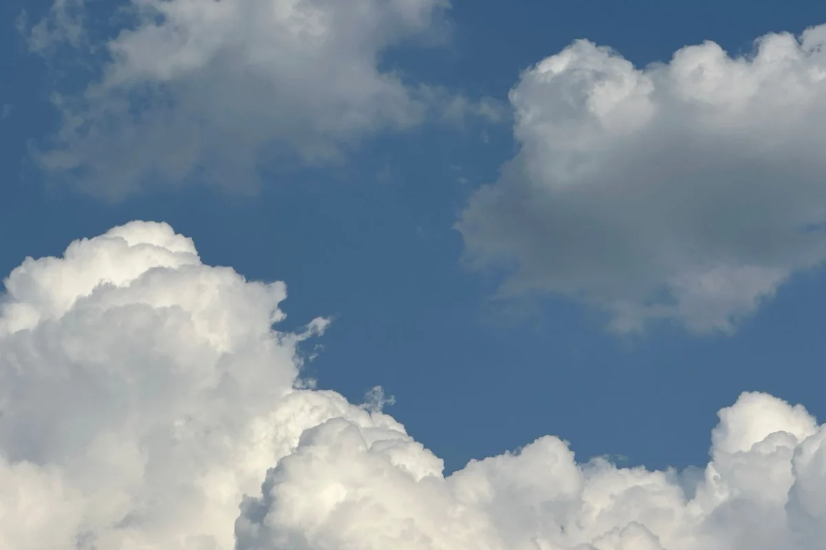 fluffy white clouds against clear blue sky