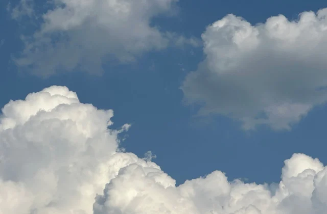 fluffy white clouds against clear blue sky