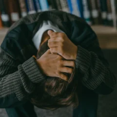 a person holding hair with head down