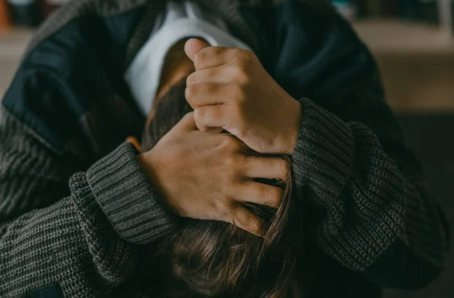 a person holding hair with head down