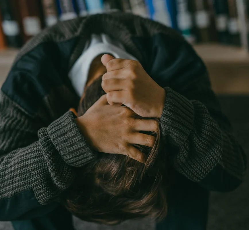 a person holding hair with head down