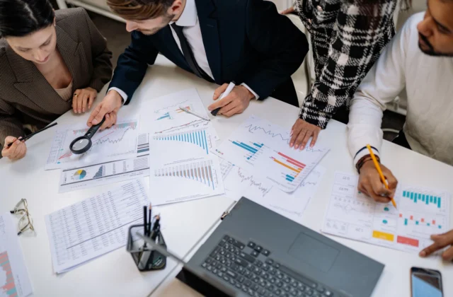 people working together by table at office